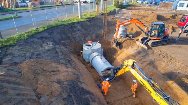 Excavator digging trench for sewer laying connecting underground storm sewer system 