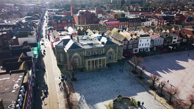 Aerial drone view of Salisbury Market Square featuring the historic Guildhall building, surrounding shops and streets in Wiltshire England UK