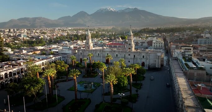 Basilica Cathedral of Arequipa in the Plaza de Armas with volcanoes in the background at sunrise, Peru. Aerial drone view