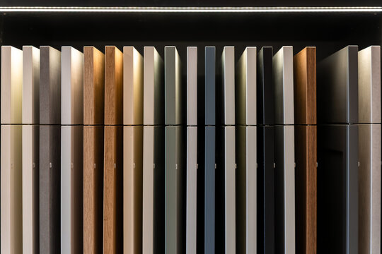 Kitchen cabinet samples on shelf with reflective display. Modern interior design material selection.