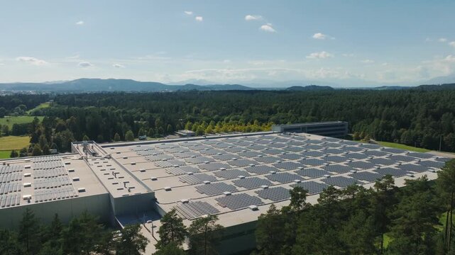 Aerial footage shows solar panels installed on a building, highlighting renewable energy production in a clear sky.