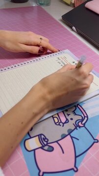 Close up hand of kid girl writing, school child doing homework sitting at table
