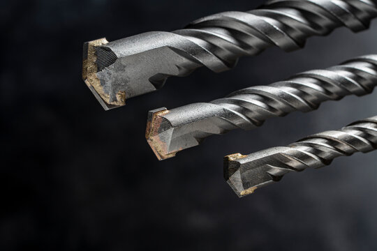Professional masonry drill bits, closeup. Three SDS plus drill bits for concrete and brick, showing carbide tips and spiral texture, ideal for construction and industrial tool marketing
