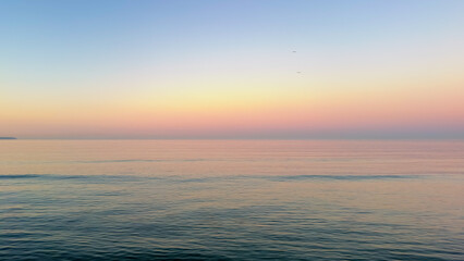 Obraz premium Minimalist sea sunset landscape with gradient sky. Calm water surface under pastel horizon.