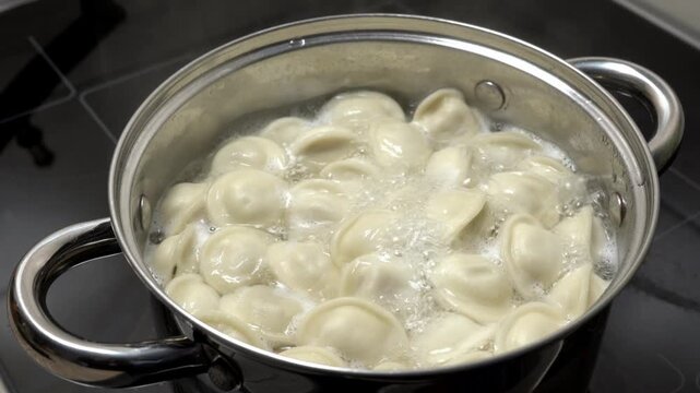 Dumplings are cooked in boiling water. The process of making homemade meat dumplings. Frozen dumplings are dropped into boiling water, stirred, and brought to a boil. Homemade semi-finished products