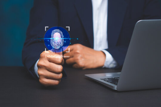 Businessman using fingerprint login on laptop security system