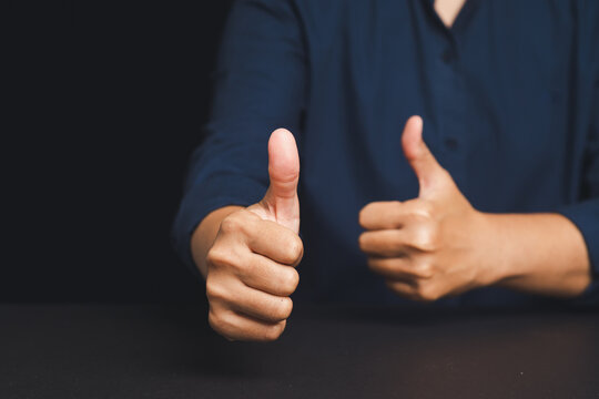 Business person showing thumbs up approval gesture