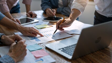 Team collaborating on business charts and laptop © AmDmLib