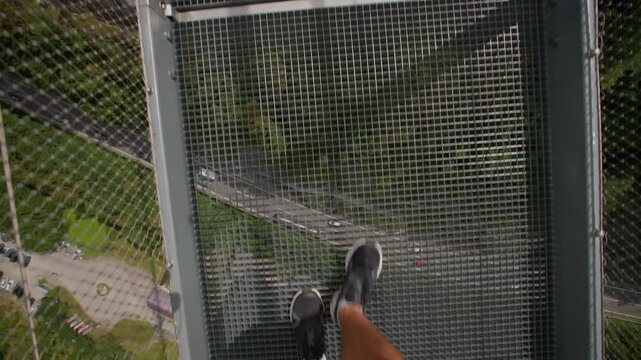 Tourist's legs walking on the Highline 179 suspension bridge in the Austrian Alps. Travel and tourism in Europe beautiful landscapes.