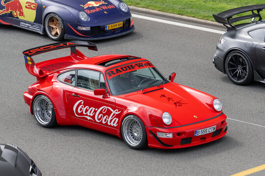Stavelot, Belgium - April 5th 2026 : View on a red Porsche 964 Rauh-Welt Begriff driving on a street surrounded by other cars.