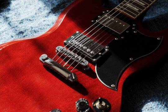 Electric red sg guitar on blue plaid. Music rock background in the day light