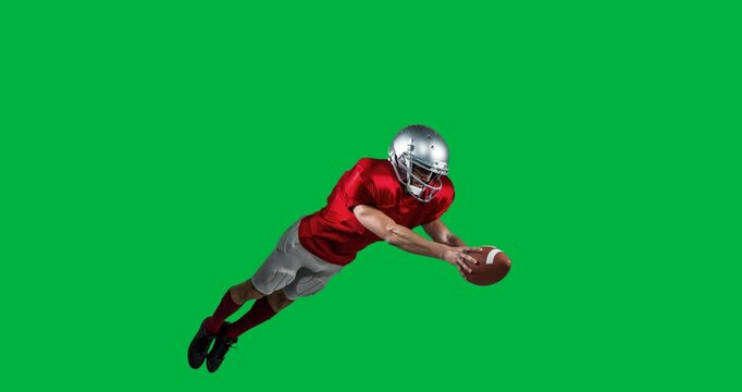 Male rugby player wearing helmet catching a rugby ball against black background