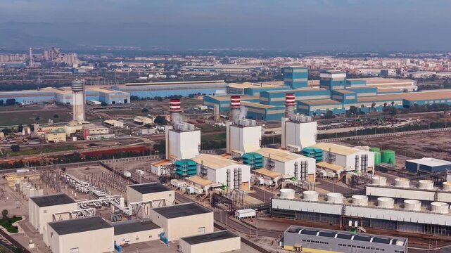 Combined cycle gas power plant with turbines, heat recovery steam generators, exhaust stacks and high-voltage switchyard delivering electricity to transmission grid