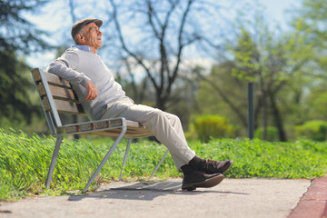 Fototapeta premium Senior man relaxing on a wooden bench