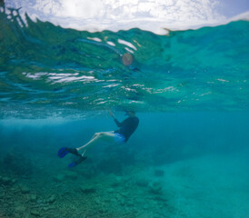 Split View of Snorkeler in Turquoise Caribbean Water Beneath Blue Sky © PatrickW