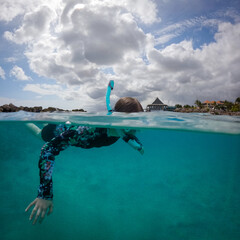 Split View of Snorkeler in Turquoise Caribbean Water Beneath Blue Sky © PatrickW