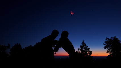 Amateur astronomer using binoculars for observing stars, planets, Moon and other celestial objects. © astrosystem