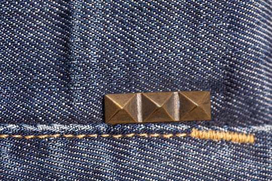 Pyramid metal studs jeans. Denim background.