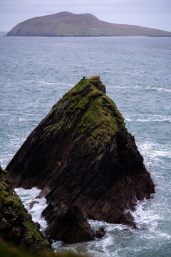 Dramatic sea stack covered in green moss Irish coastline
