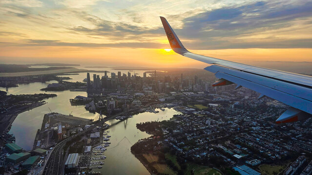 View from the airplane window of Sydney.Sunset view over city and river from airplane wing during descent to Brisbane with skyline in distance