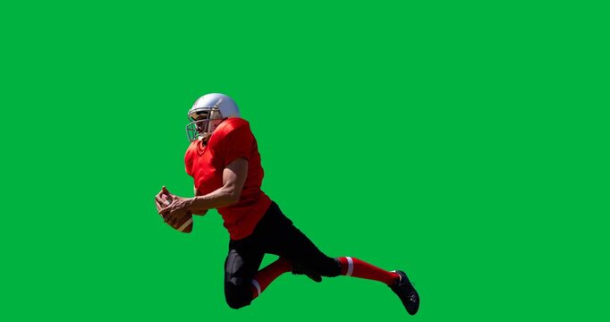 Male rugby player wearing helmet catching a rugby ball against black background
