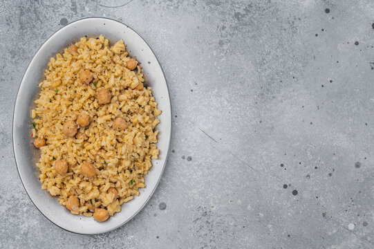 Traditional Turkish bulgur pilav nohutlu with chickpeas healthy vegan dish on light stone background overhead