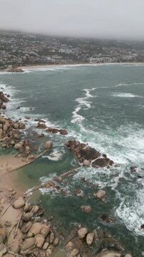 Vertical 4K Drone Aerial of Camps Bay Rocks and Maiden&rsquo;s Cove Tidal Pool, Crashing Atlantic Waves in Cape Town