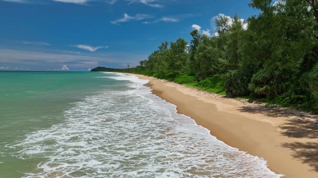 Aerial view fly back and ascending over sea wave crashing on beach, Thailand