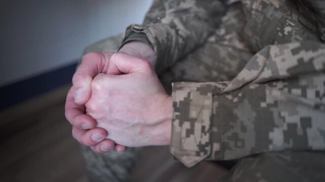A sad soldier in camouflage uniform suffers from post-traumatic stress disorder