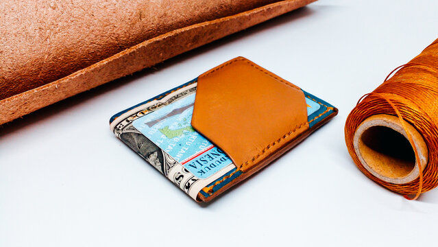 Top view of a handmade bifold leather card holder in tan and navy blue.