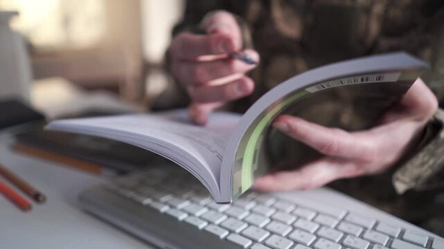 Military education. Student in soldier uniform learning at wooden desk indoors