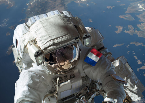 Close up view of French astronaut in outer space during a spacewalk with planet Earth in the background. Elements of this image furnished by NASA.