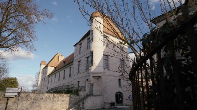 View of a historic manor with its characteristic round tower in the village of Issigeac. Old limestone building. Slow tracking shot in slow motion.