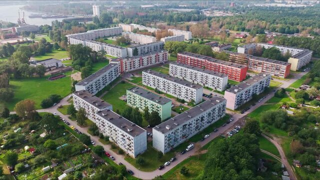 Drone pulls back showing Tosmare housing near industrial port Liepaja