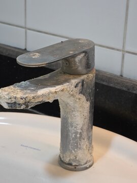 heavy limescale and calcium buildup on bathroom water faucet