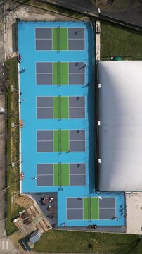 Top Down Aerial View of People Playing Pickleball on Blue Courts