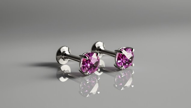 Two metallic butt plugs with pink heart crystals resting on a mirrored surface with a gray backdrop. Blurred focus. Theme of adult toys.