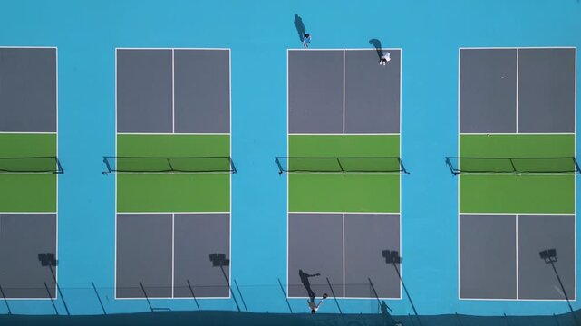 Top Down Aerial View of People Playing Pickleball on Blue Courts