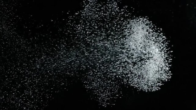 Liquid being expelled into a dark space, droplets and flow motion