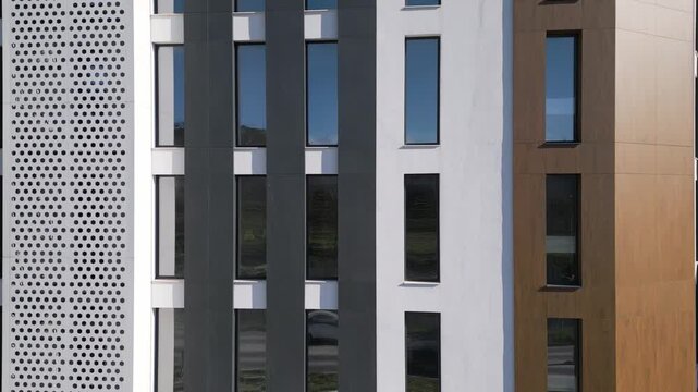 Aerial tilt up of modern residential building facade with windows and balconies