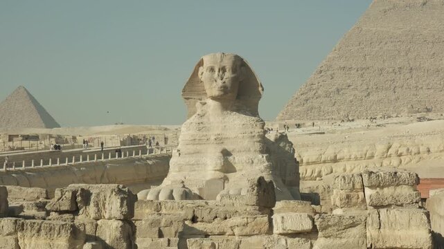 Great Sphinx statue against background of ancient Egyptian pyramids of Giza plateau in Cairo.