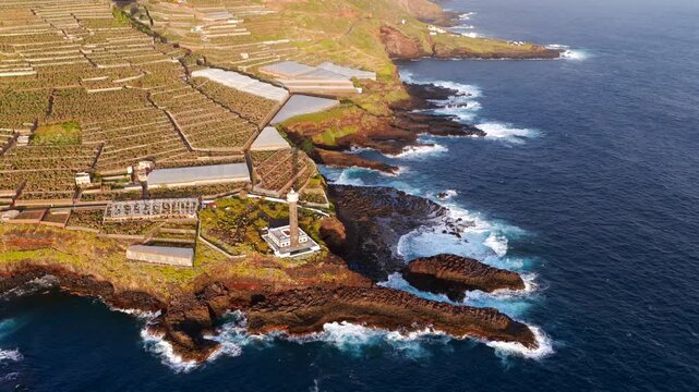Aerial View of La Fajana Lighthouse and Coastal Banana Plantations at Sunrise; Maritime Infrastructure, Industrial Agriculture, and Solar Azimuth, La Palma, Canary Islands, Spain