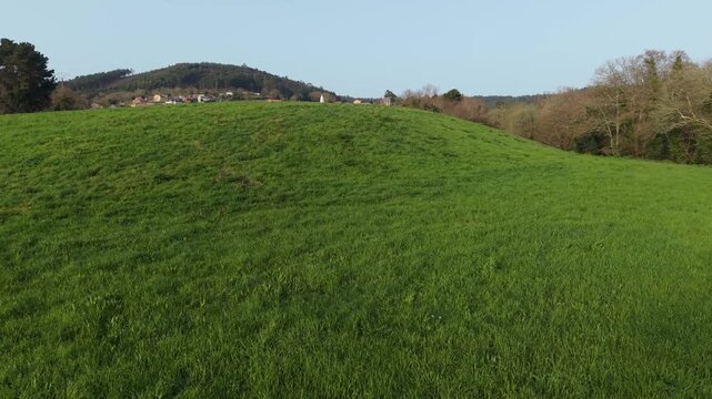 Green Hills With Parroquia y Cementerio de San Paio de Bex&aacute;n In Cospeito In Galicia, Spain. Aerial Drone Shot