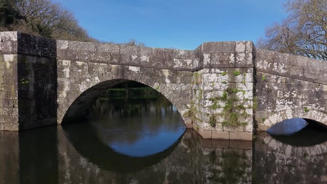 Ancient Stone Bridge Over The Xallas River With Brandomil Roman Bridge In Zas, Galicia, Spain. Aerial Sideways Shot