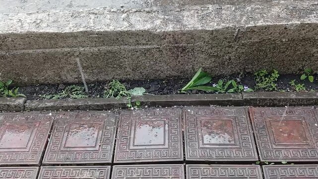 Stock video of hail falling in the yard on the tiles