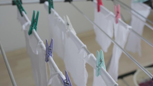 Close-up of hanging wet laundry on a manual clothes drying rack