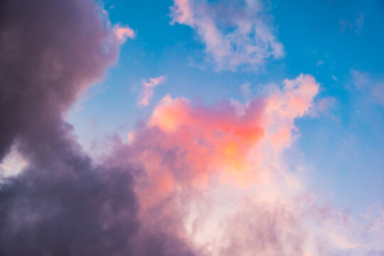 Fairytale blue sky with sugar cotton pink cloud in a dreamy background. Morning dawn. Amazing heaven. Nature wallpaper. Idyllic backdrop. Romantic atmosphere. Textured abstract. High quality photo.