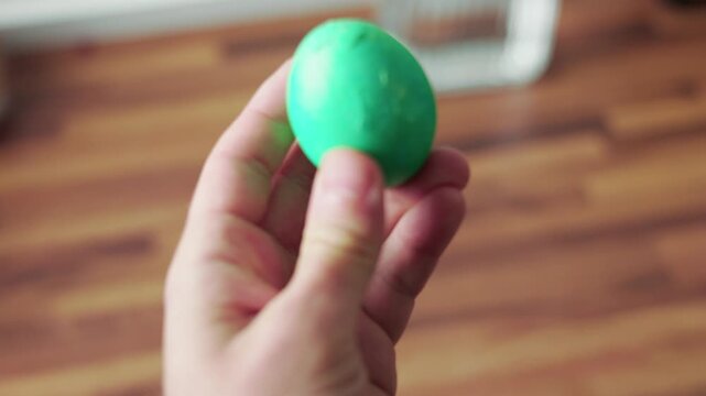 Peeling dyed easter egg shell by hand closeup first person view