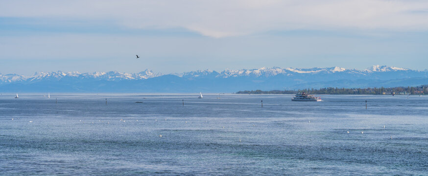 Lake constance panoramic with distant snowy alps and boats