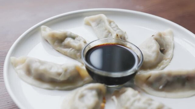 Close-Up of Gyoza with Soy Sauce Served on White Plate